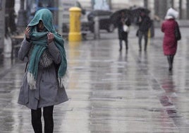 Una mujer se refugia de la lluvia en una imagen de archivo.