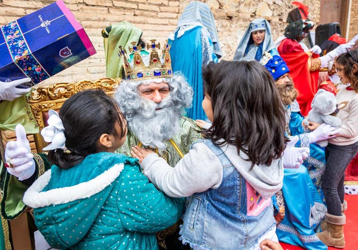 Melchor abraza a dos niñas, este lunes en una pedanía de Valencia.