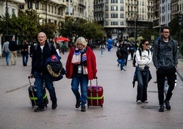 Turistas cargados con maletas, en la plaza del Ayuntamiento de Valencia.