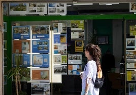 Una joven observa los anuncios de una inmobiliaria en Valencia.