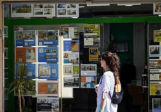 Una joven observa los anuncios de una inmobiliaria en Valencia.