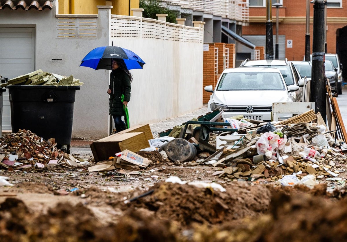 Una persona camina bajo la lluvia en una localidad de la zona cero, este viernes.