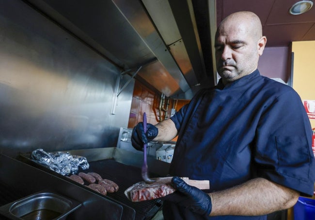 Quique Medina prepara carne en su restaurante.