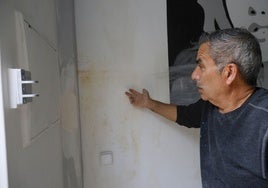 José muestra las humedades en su pared.