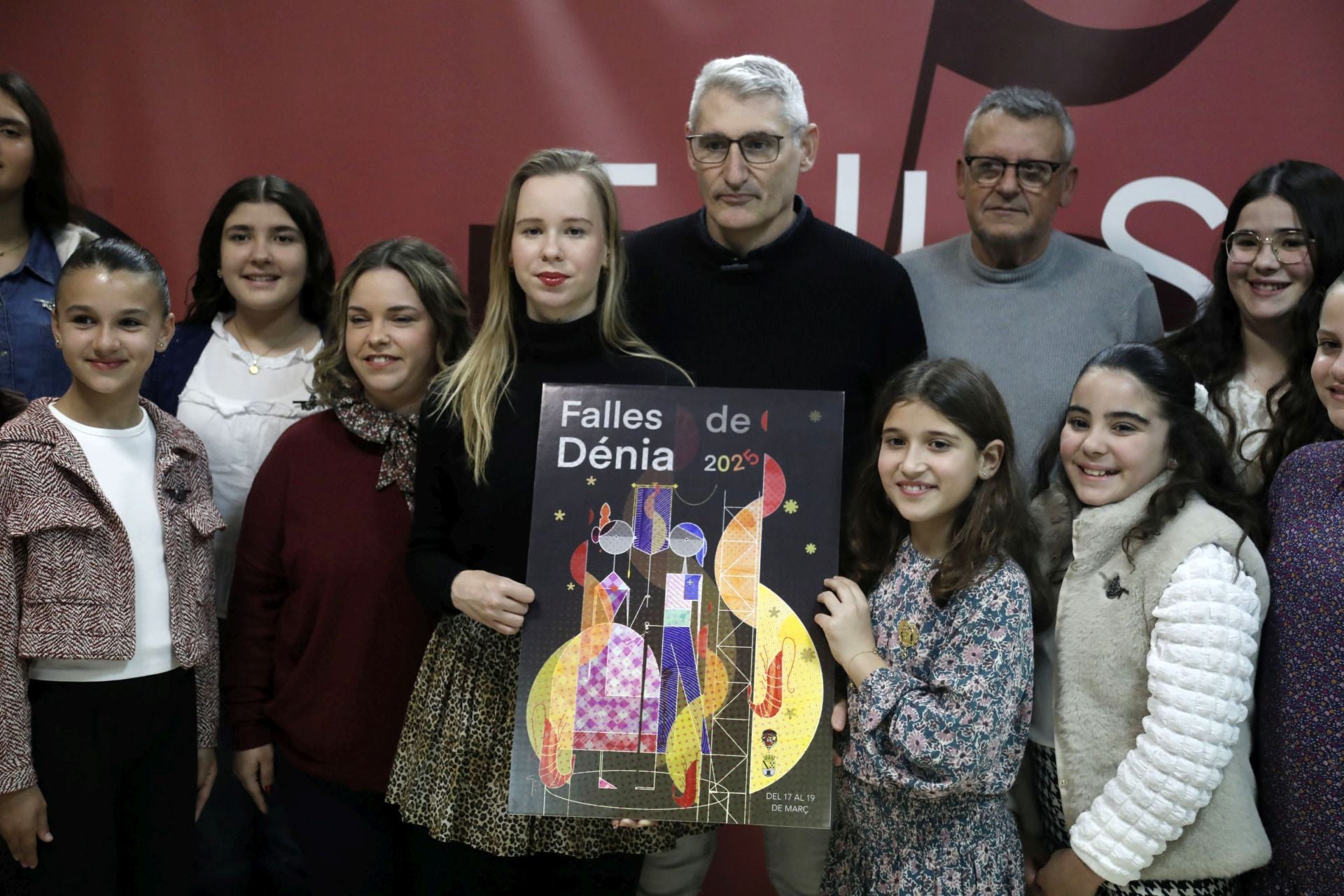 Las falleras mayores de Dénia sujetan el cartel de las Fallas 2025.