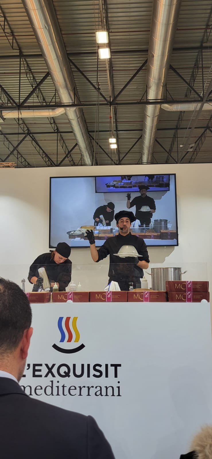 Imagen secundaria 2 - Arriba, momento de la elaboración de la coca de fira. Sobre estas líneas, las autoridades reciben el cofre de la marca MOS y otro momento de la demostración gastronómica.