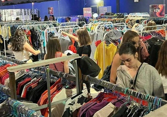 Clientes en un mercadillo de ropa.