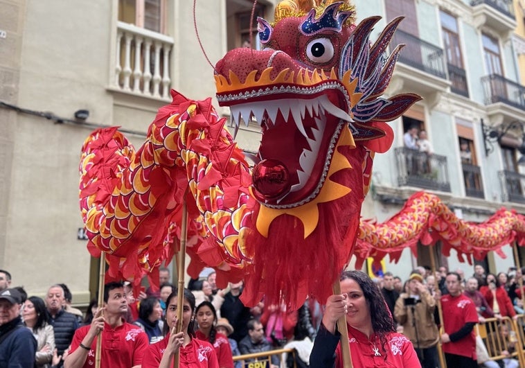 Varios participantes sostienen un dragón típico de la cultura china.