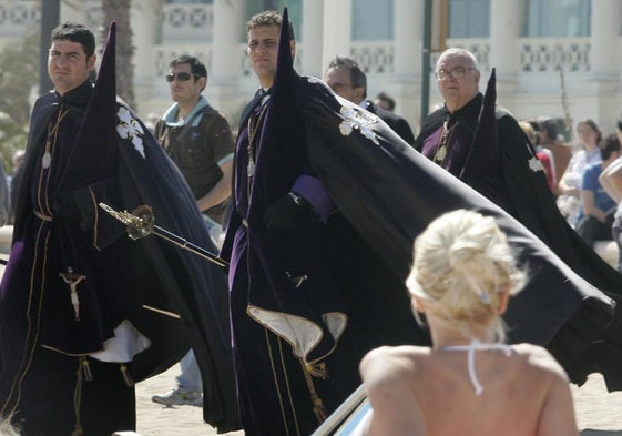 Una mujer toma el sol en la playa de la Malvarrosa de Valencia en medio de una procesión, en una imagen de archivo.