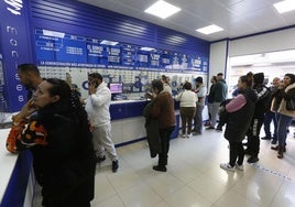 Clientes en una administración de loterías. Imagen de archivo.