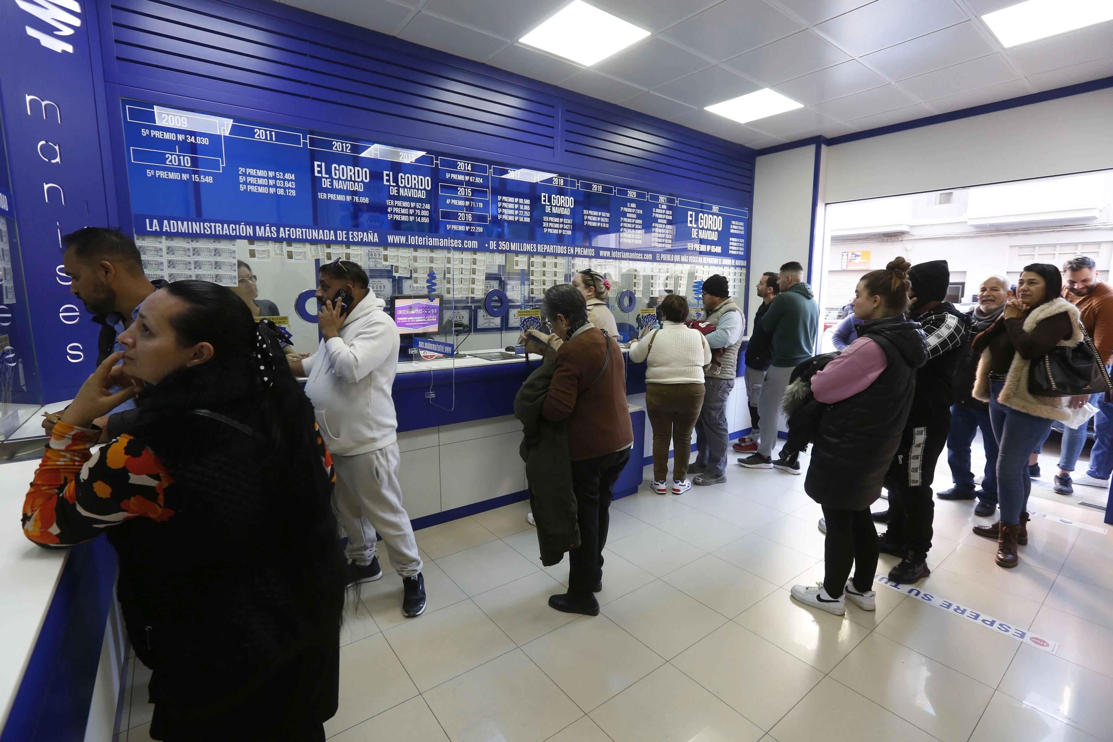 Clientes en una administración de loterías. Imagen de archivo.