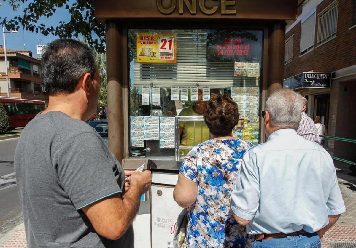 Varias personas hacen cola para comprar un décimo.