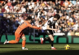 El centrocampista del Valencia Javier Guerra (d) pelea un balón con el centrocampista del Celta Fran Beltrán (i).