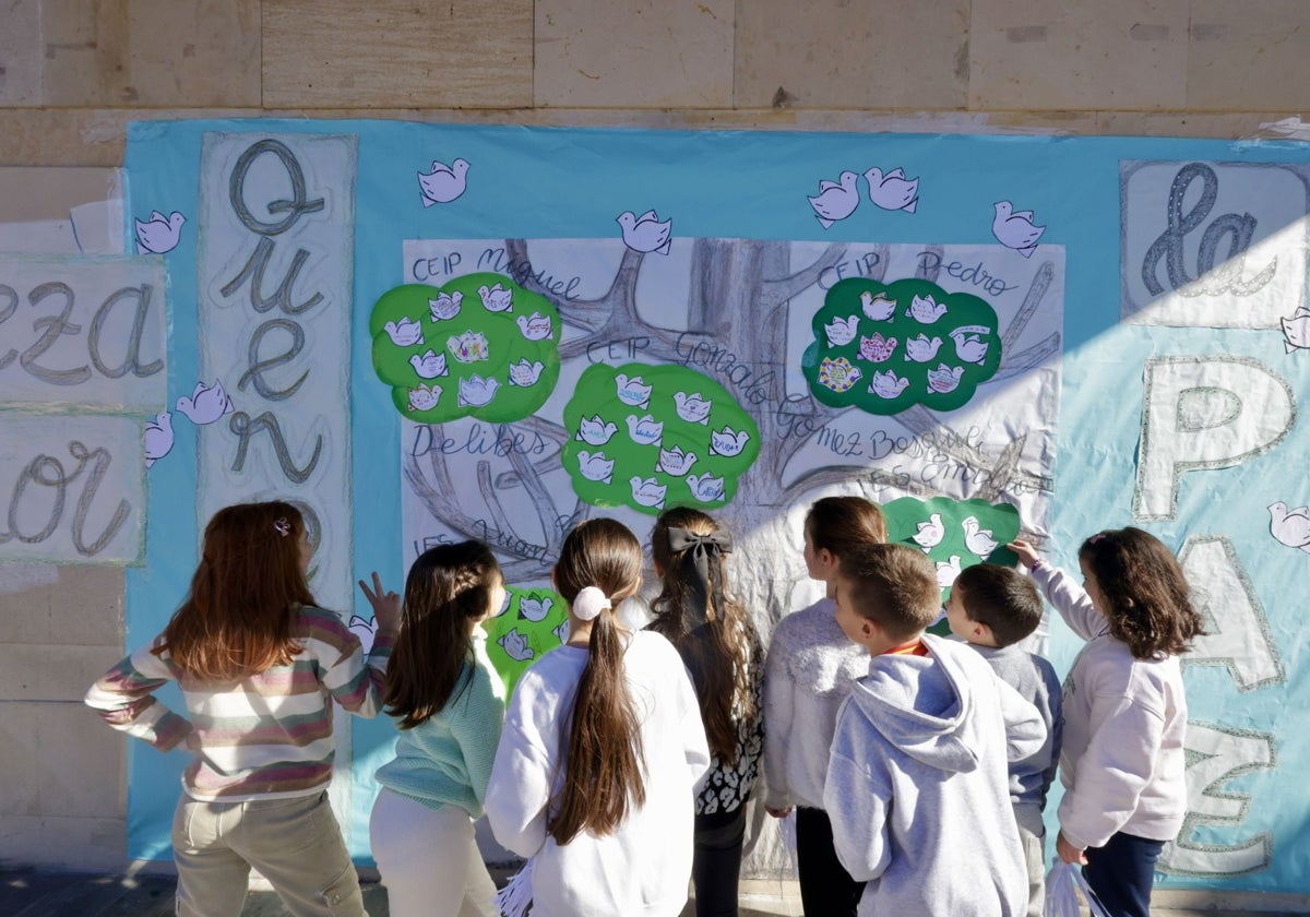 Unos niños ante un mural.