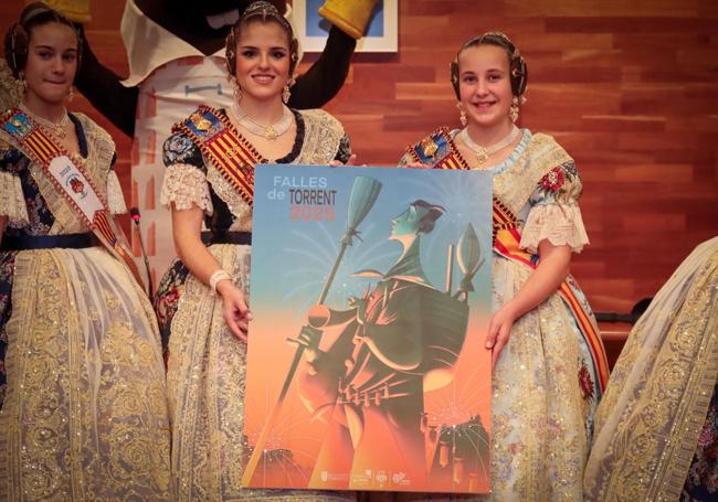 Las falleras mayores de Torrent, con el cartel anunciador de las Fallas.