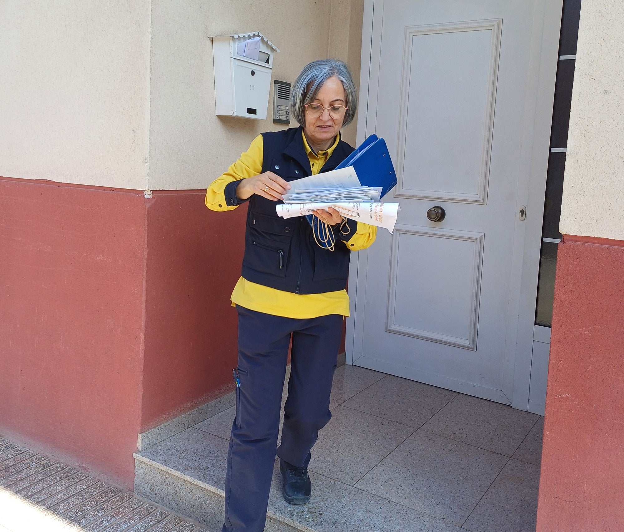 Imagen secundaria 1 - Arriba, Mª Carmen atiende a una cliente en la oficina. Sobre estas líneas, en su recorrido por el mucipio entregando paquetes, notificaciones y alguna que otra carta.