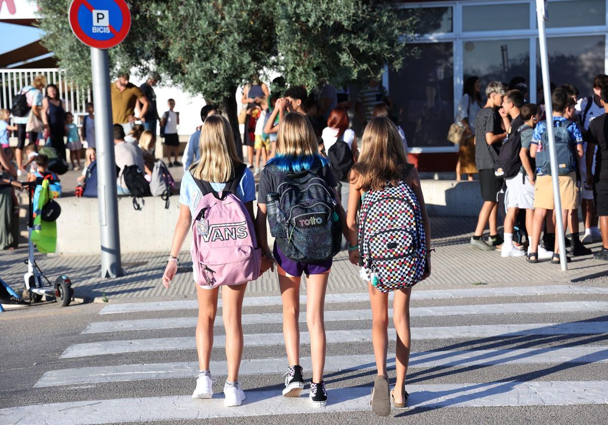 Varios niños en la entrada de un colegio.