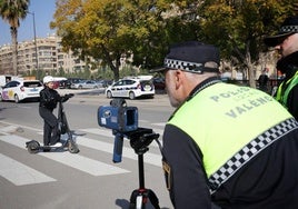 Un policía vigila el radar para medir la velocidad de los patinetes este lunes.