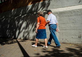 Dos jubilados pasean por una calle.