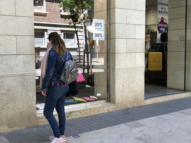 Una mujer mira el escaparate de un establecimiento de Dénia.