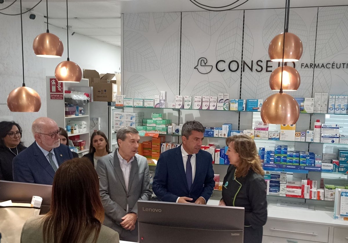 Mazón, junto al conseller de Sanidad y la propietaria de la farmacia este martes.