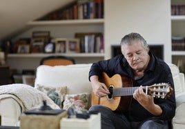 Francisco toca la guitarra en el salón de su casa.