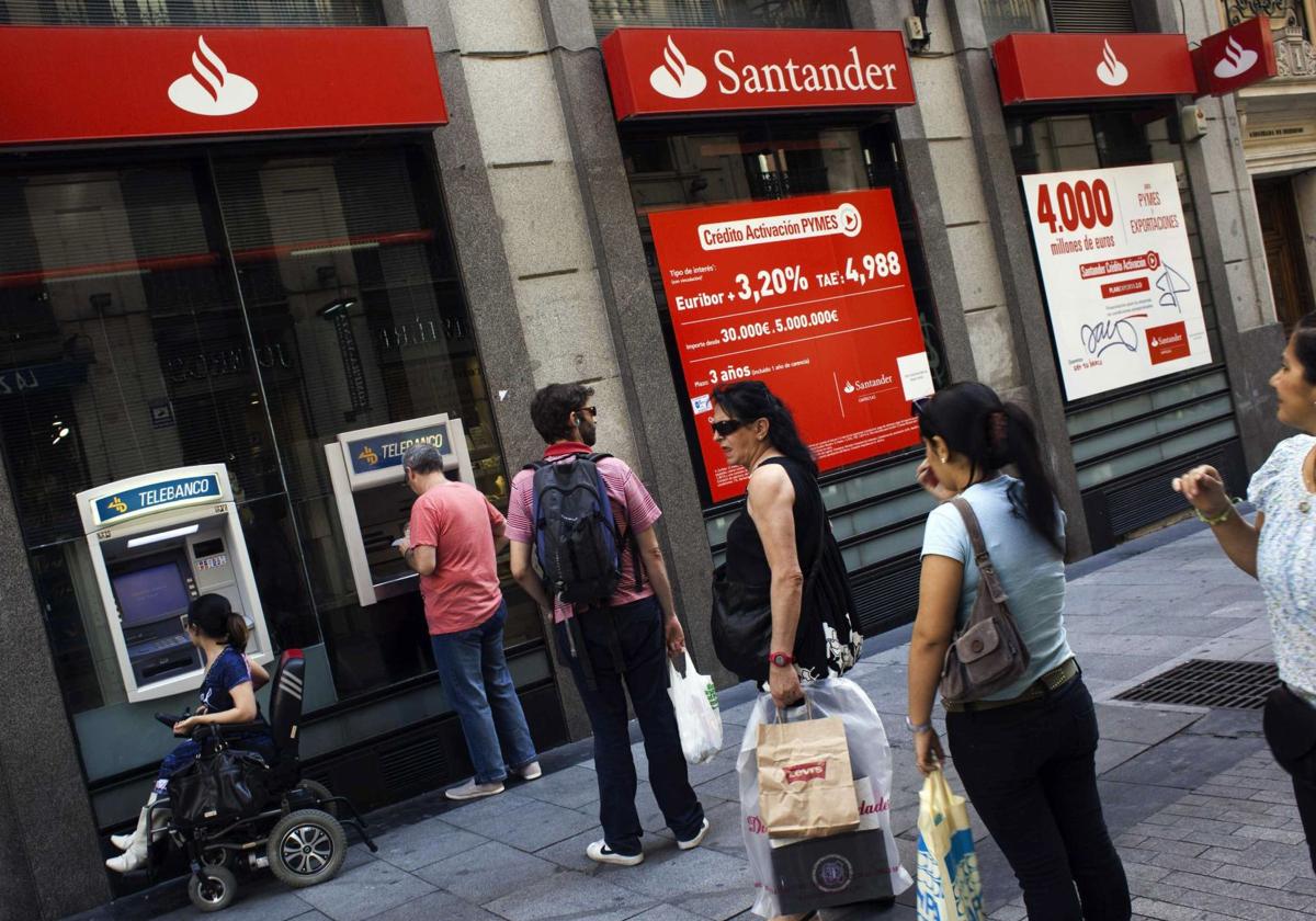 Varias personas hacen cola en un banco de Santander.