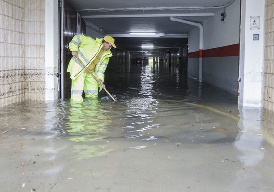 Un operario achica agua de un local inundado en Gandia en una foto de archivo.