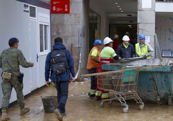 Un grupo de empleados del sector de la construcción trabaja en la reparación de un centro de salud tras la dana.