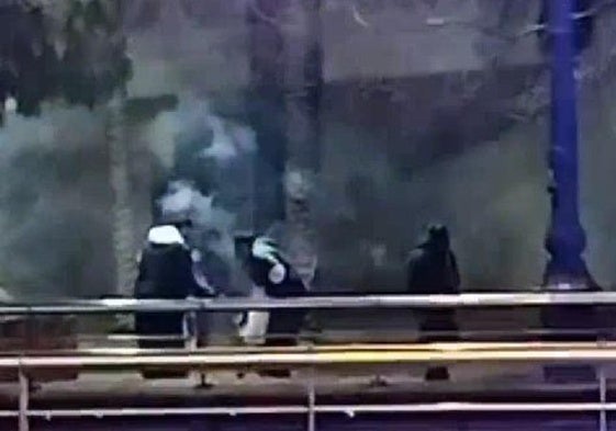 Un grupo de personas haciendo guerra de bengalas en los jargines del Muvim.