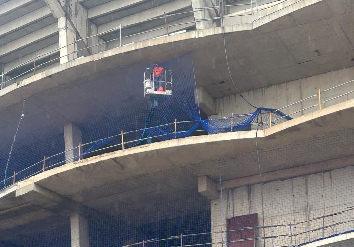 Operario colocando este martes la malla de seguridad en el edificio de Corts Valencianes.