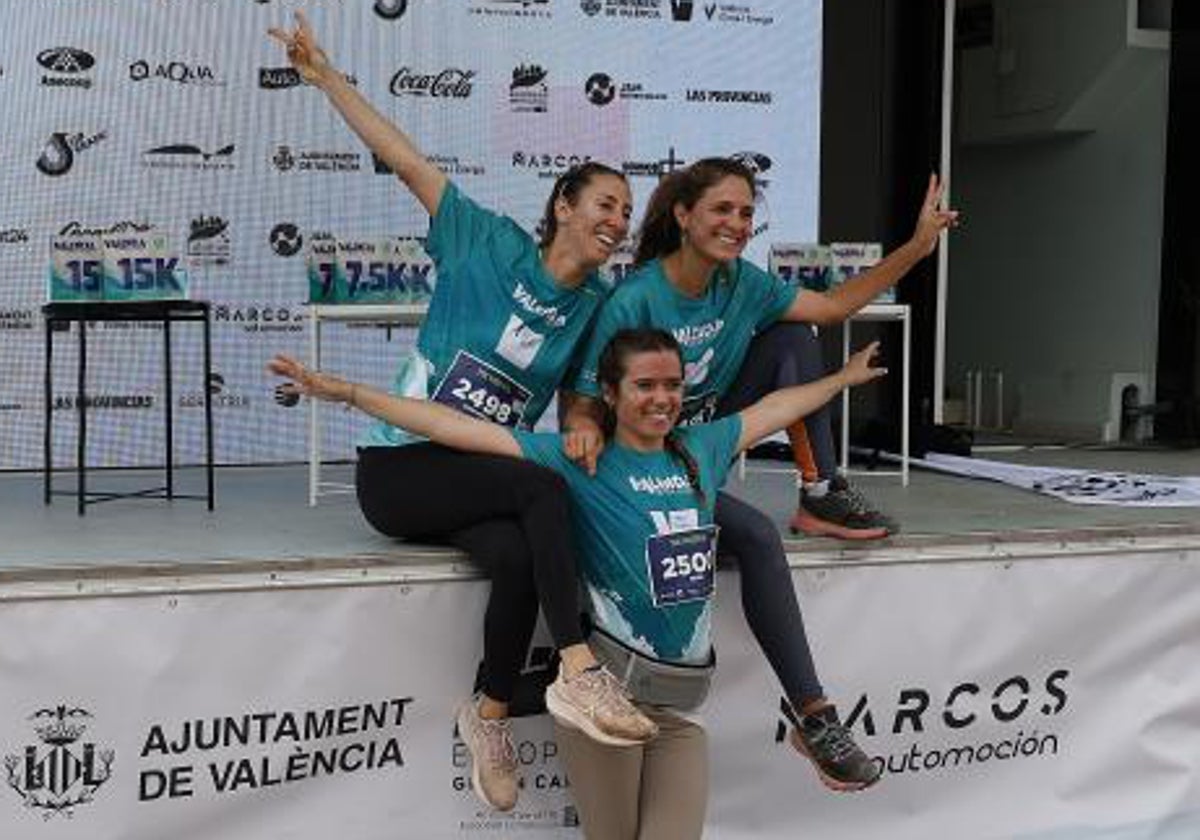 Tres amigas posan sonrientes en el podio después de completar la carrera del año pasado.