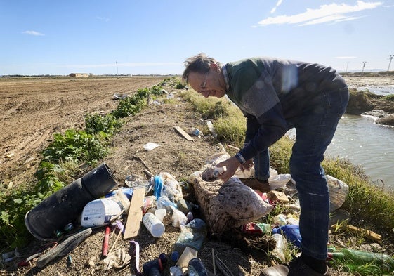 Un agricultor muestra los vertidos arrastrados por el agua a la Albufera.