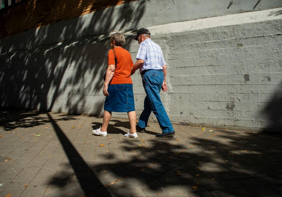 Dos jubilados pasean por una calle.