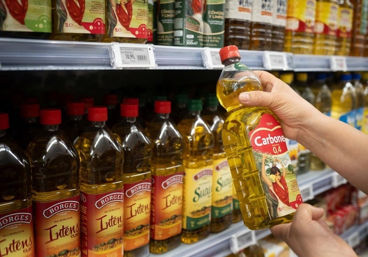 Una persona sostiene una botella de aceite