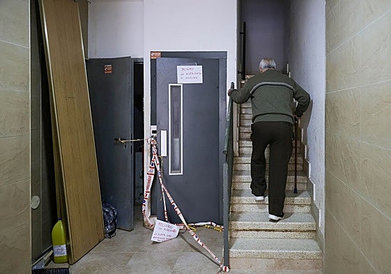 Un vecino sube por la escalera en Paiporta al tener averiado su ascensor tras la dana.