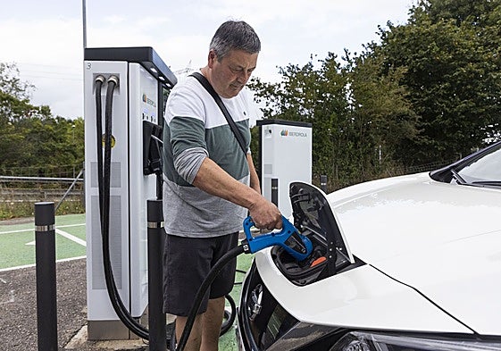 Un usuario recarga su vehículo en un área de servicio.