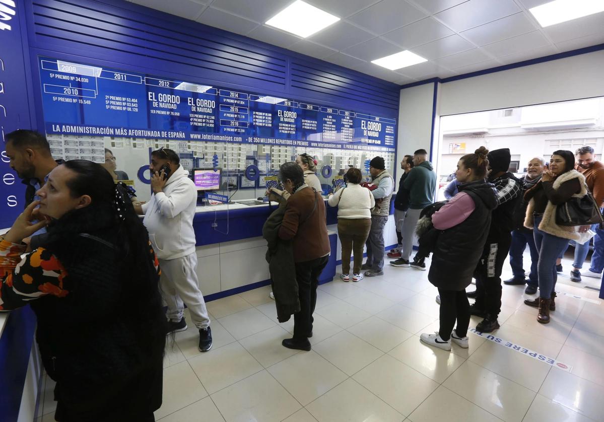 Clientes en una administración de loterías. Imagen de archivo.