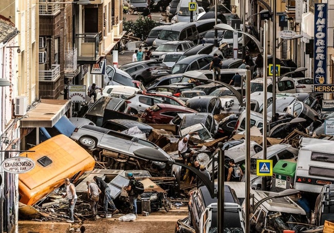 David Moreno, en el centro de la imagen, camina sobre los coches en la avenida Gómez Ferrer el 30 de octubre.