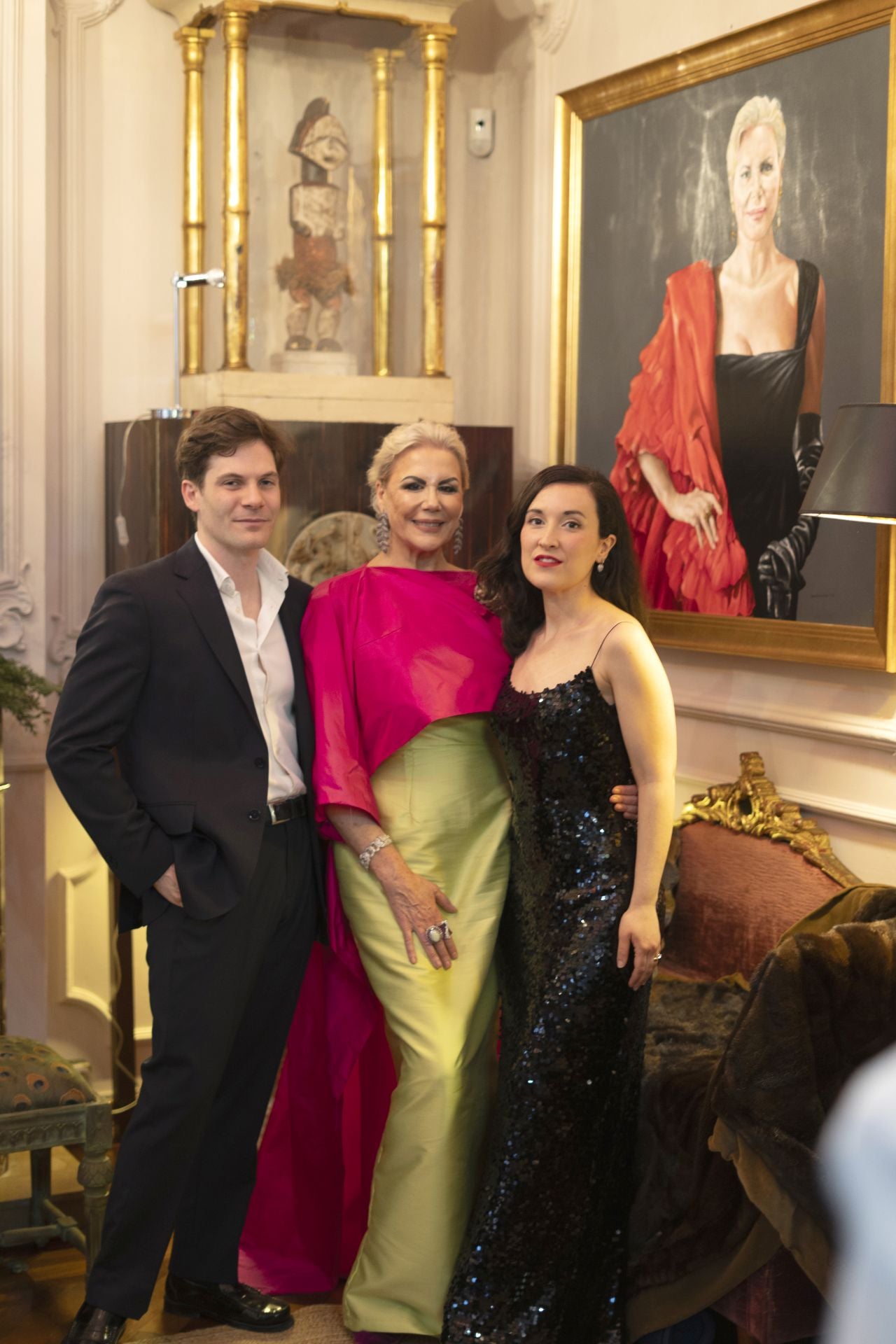Laura Fitera, con los músicos que actuaron en su fiesta. A la derecha, el retrato que le encargó a Enrique Senís.