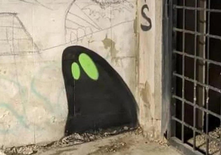 Uno de los grafitis de sombras con ojos verdes.