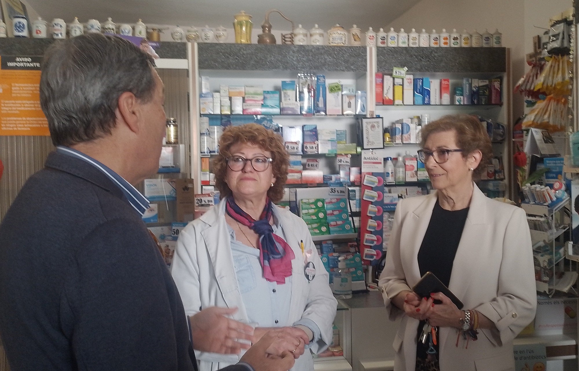 El conseller, durante la visita a la farmacia del pueblo. Abajo, entrando al consultorio médico.