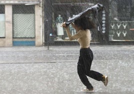 Una mujer se protege de la lluvia en una imagen de archivo.