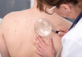 Una dermatóloga comprueba la piel de un paciente.