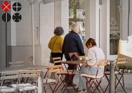 Una mujer consulta el ordenador en una terraza de un bar en Valencia.