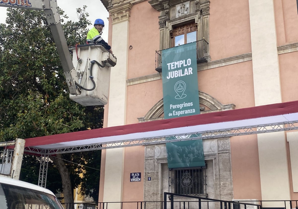 Imagen principal - Cartel del año jubilar Peregrinos de Esperanza, banderines que decoran la calle de la Paz y montaje del mercado de l'escuraeta.
