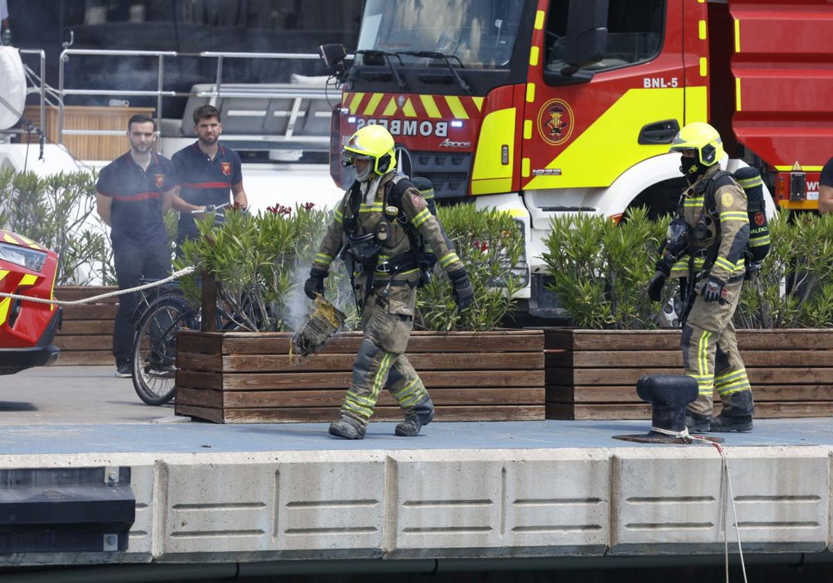 Dos de los bomberos que han intervenido este lunes en el puerto de Valencia.