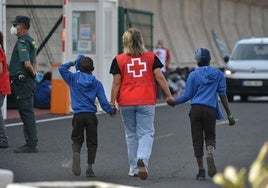 Una voluntaria atiende a dos menores extranjeros no acompañados recién llegados a Canarias.
