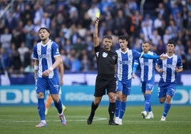 Gil Manzano muestra una amarilla durante el partido entre el Alavés y el Valencia.