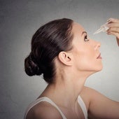 Una mujer se echa gotas en los ojos.